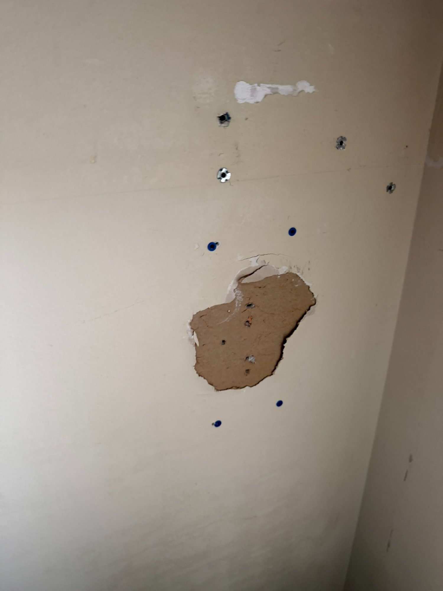 torn drywall with anchor holes needing wallpaper prep