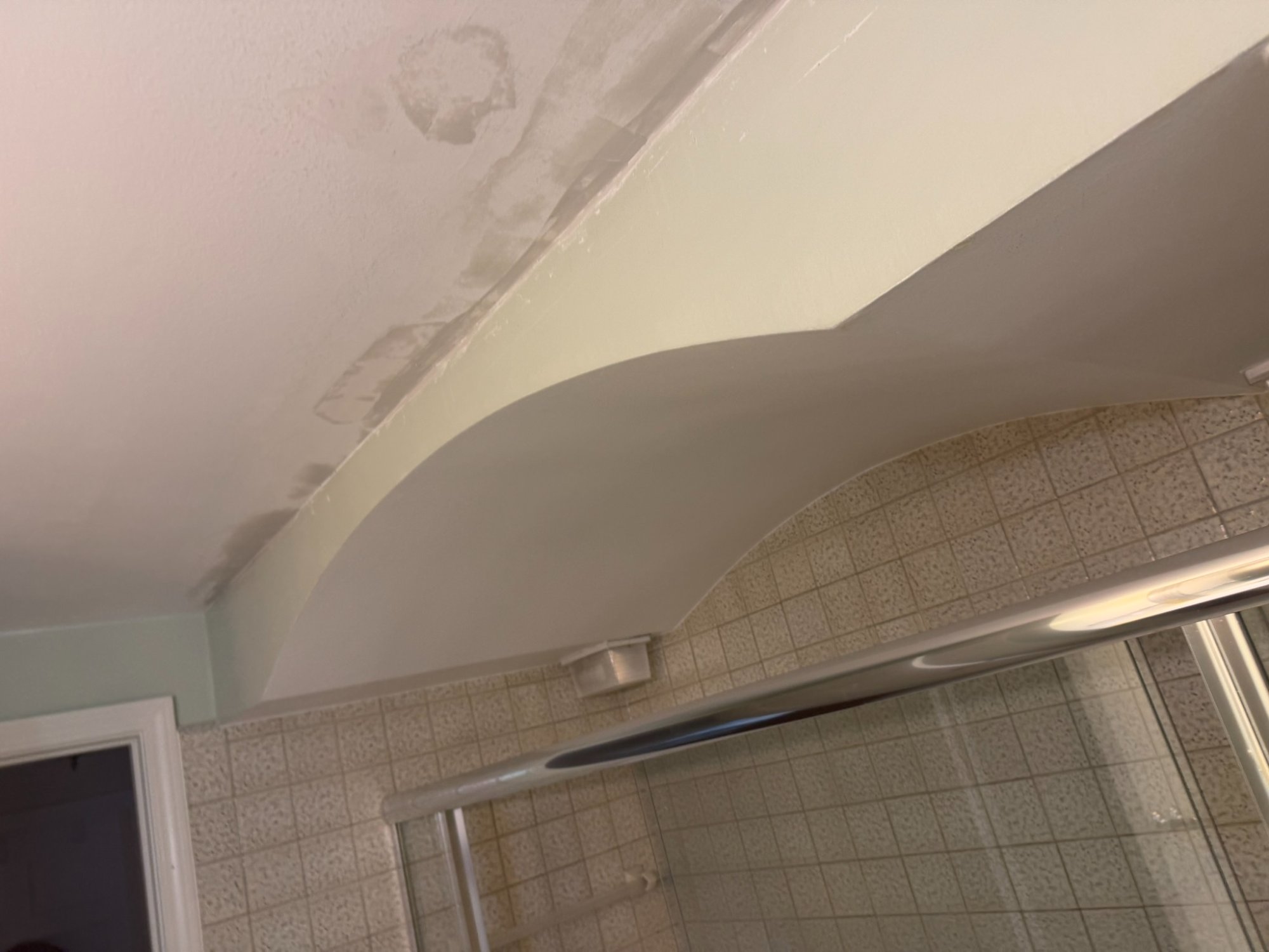 water damage on bathroom ceiling requiring repair before wallpaper prep