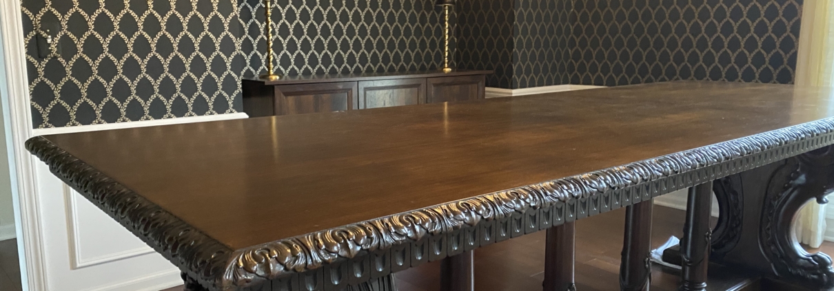 Henry Ford's table from head position looking up showing ornate carved edge with black and gold wallpaper by Bernau Designs