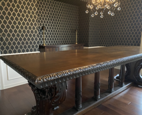 Henry Ford's table from head position looking up showing ornate carved edge with black and gold wallpaper by Bernau Designs