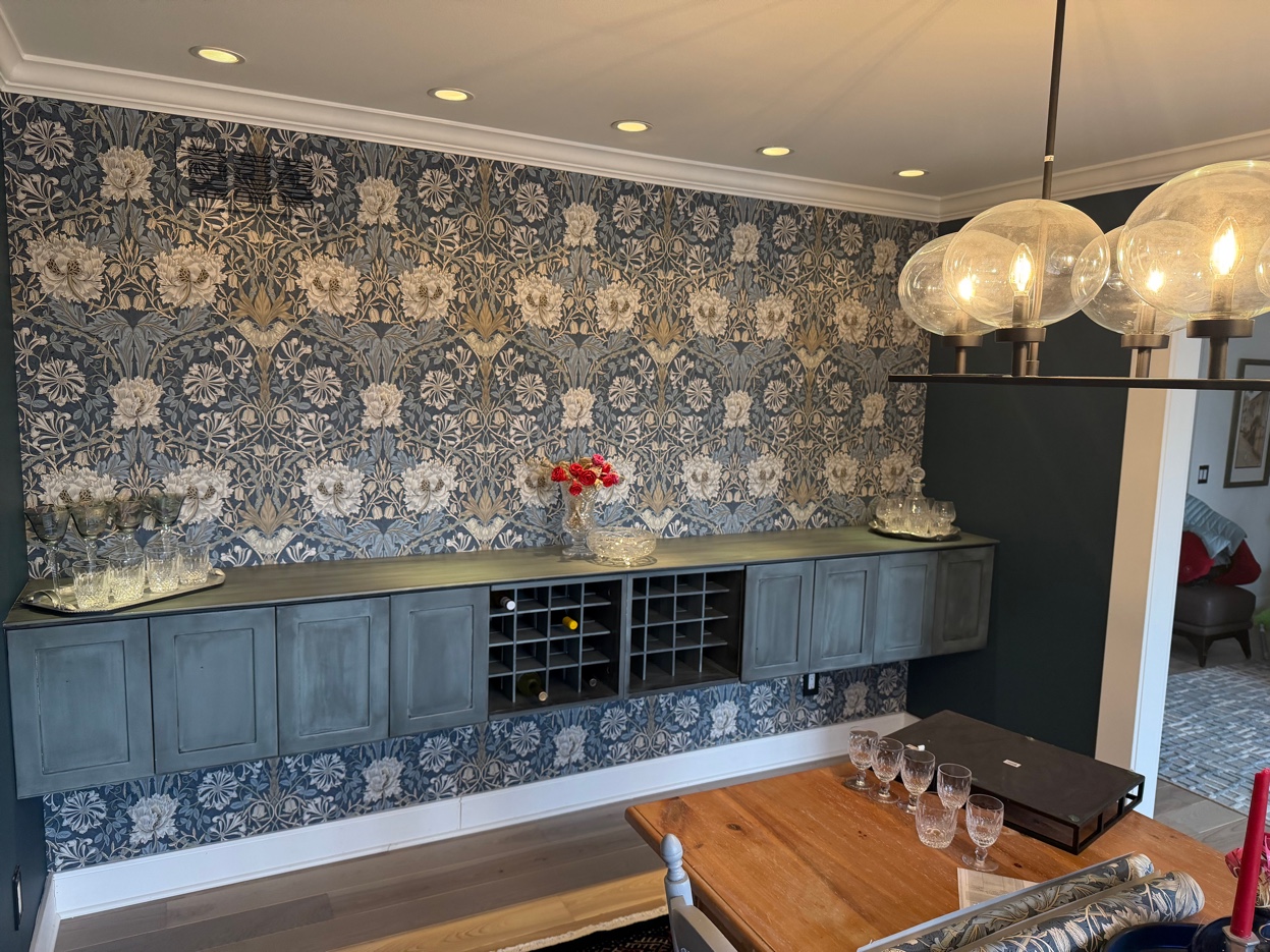 Morris & Co. Honeysuckle & Tulip dining room with wine bar and globe chandelier, viewed toward an adjoining room — Birmingham, MI. Installed by Bernau Designs.