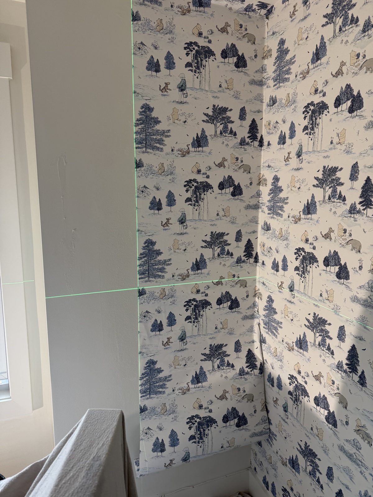 Sanderson Winnie the Pooh wallpaper turning a corner with the half-drop pattern maintained across the wall.