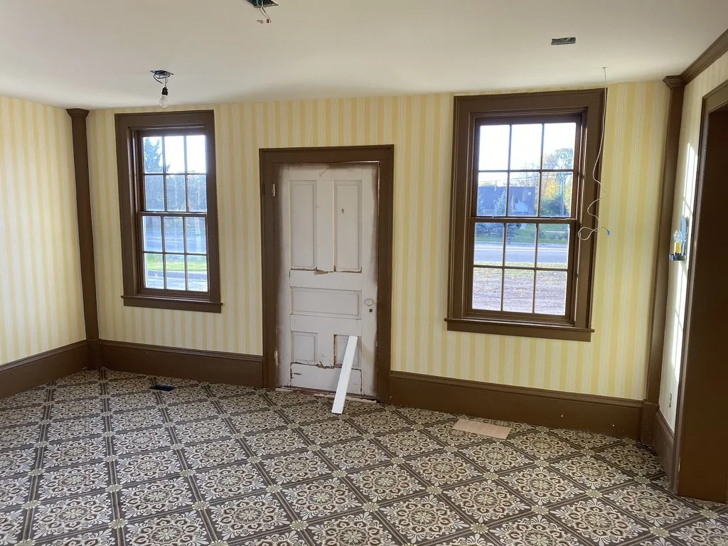 A finished first-floor room at the Niles-Barnard House with Kensington Stripe wallcovering and dark brown trim.