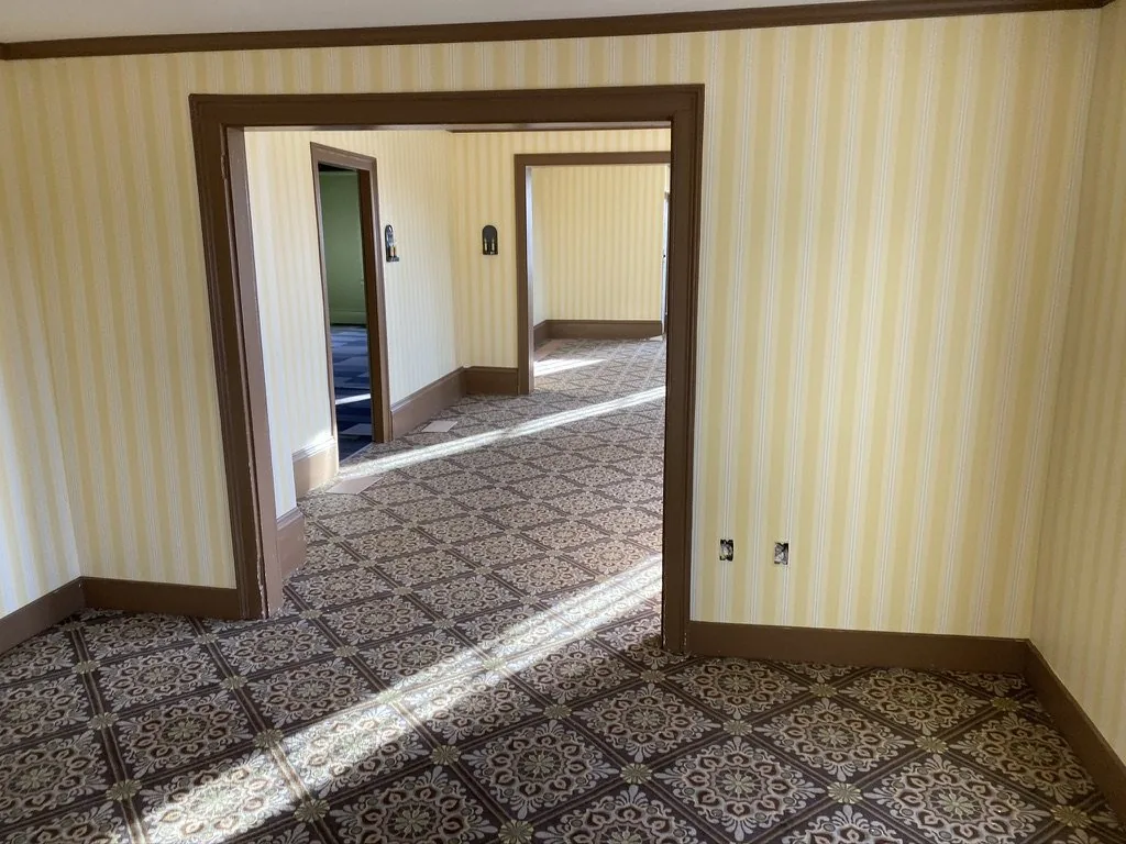 The view through three aligned doorways at the Niles-Barnard House, with the striped wallcovering reading continuous from room to room.